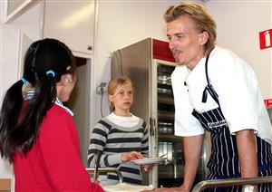 Kocken Paul Svensson i samtal med två elever på Bäckahagens skola i Bandhagen.  foto TV4